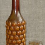 Medžiu dekoruotas butelis su stikline