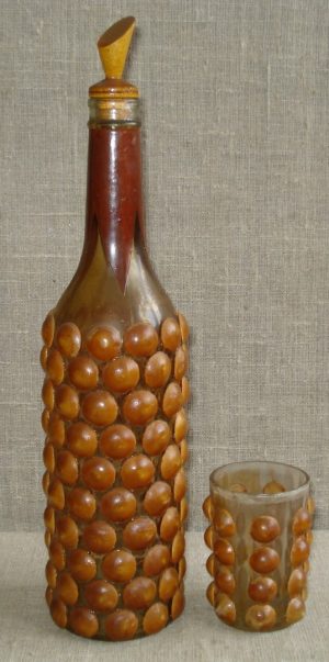 Medžiu dekoruotas butelis su stikline