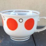 Puodelis su raudonais "žirneliais"